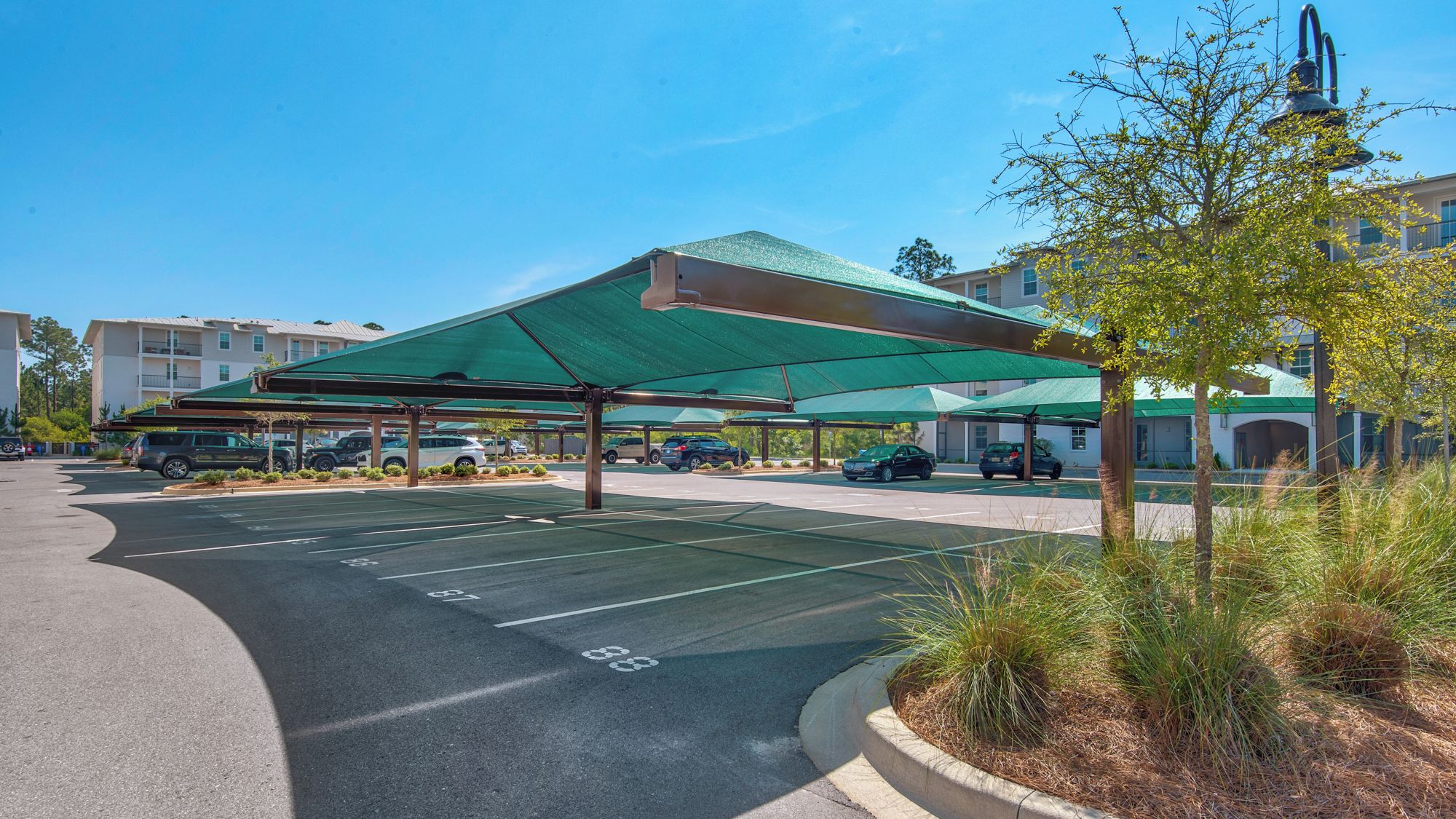 A parking area with covered parking spaces and a building in the background.
