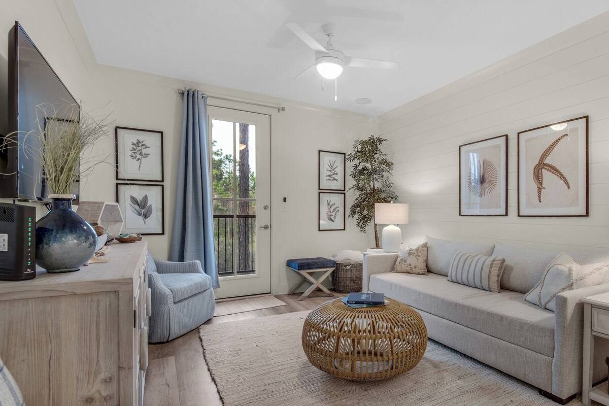 A modern living room with a sofa, a coffee table, a side table, and a TV.