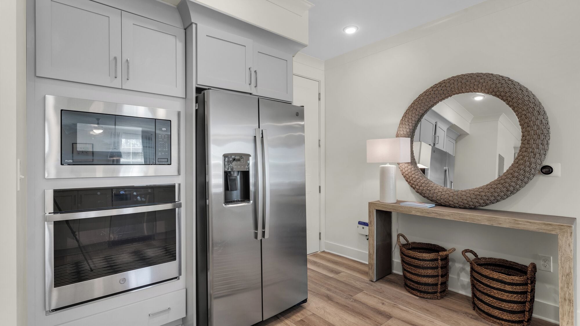 A modern kitchen with stainless steel appliances, a built-in oven, and a water dispenser.
