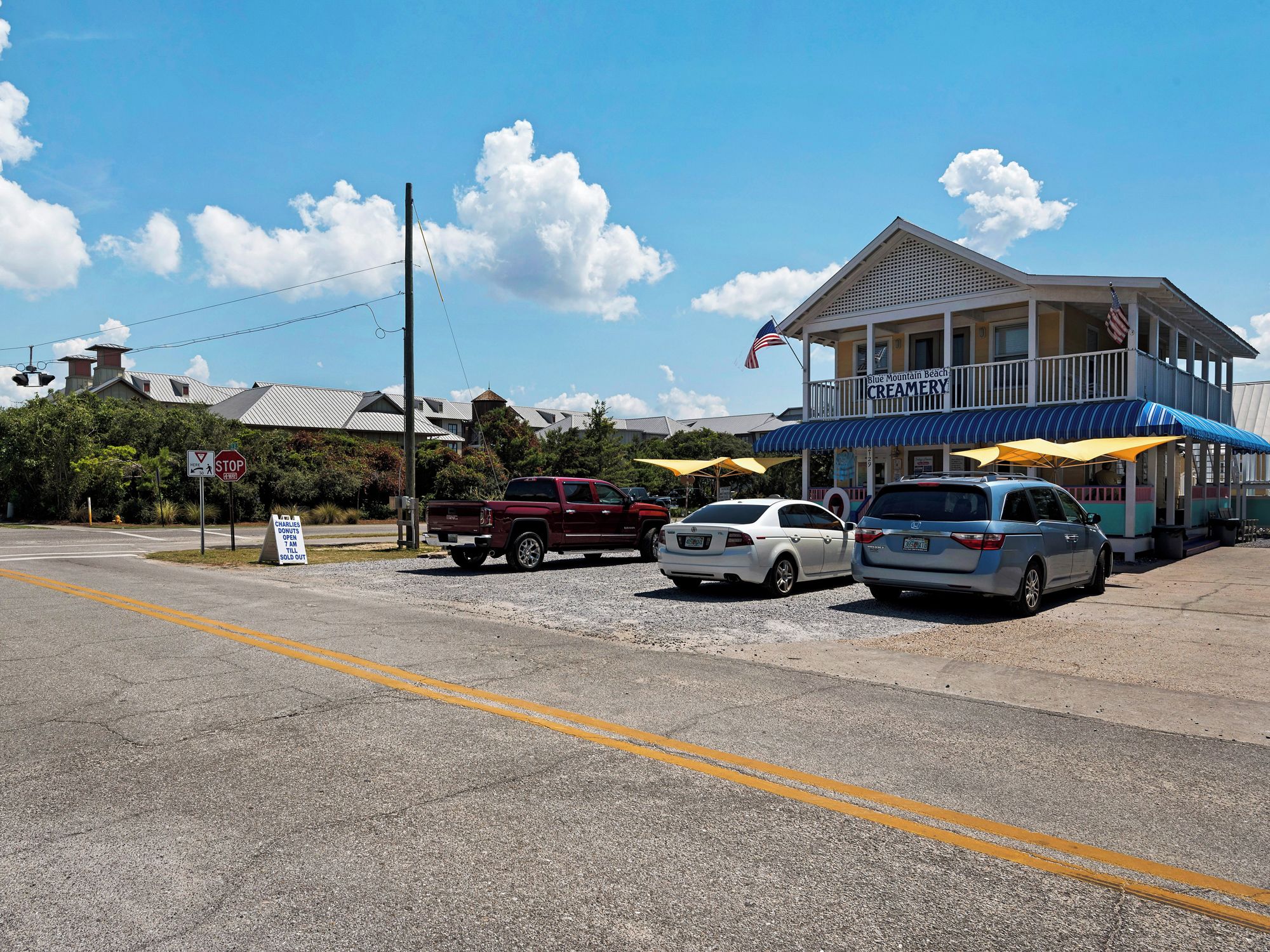 A building with a blue awning and an American flag, labeled "Blue Mountain Beach Creamery."