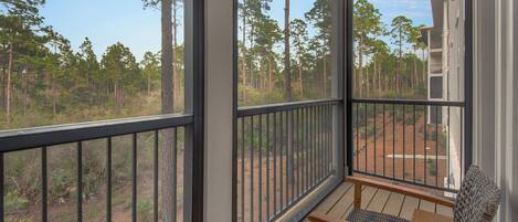 A balcony with a view of a forest.