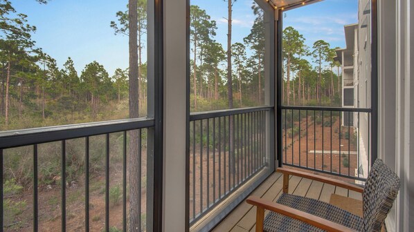 A balcony with a view of a forest. - Pinewood30A (Santa Rosa Beach)