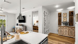 A modern kitchen with a white countertop, stainless steel sink, and a built-in dishwasher.