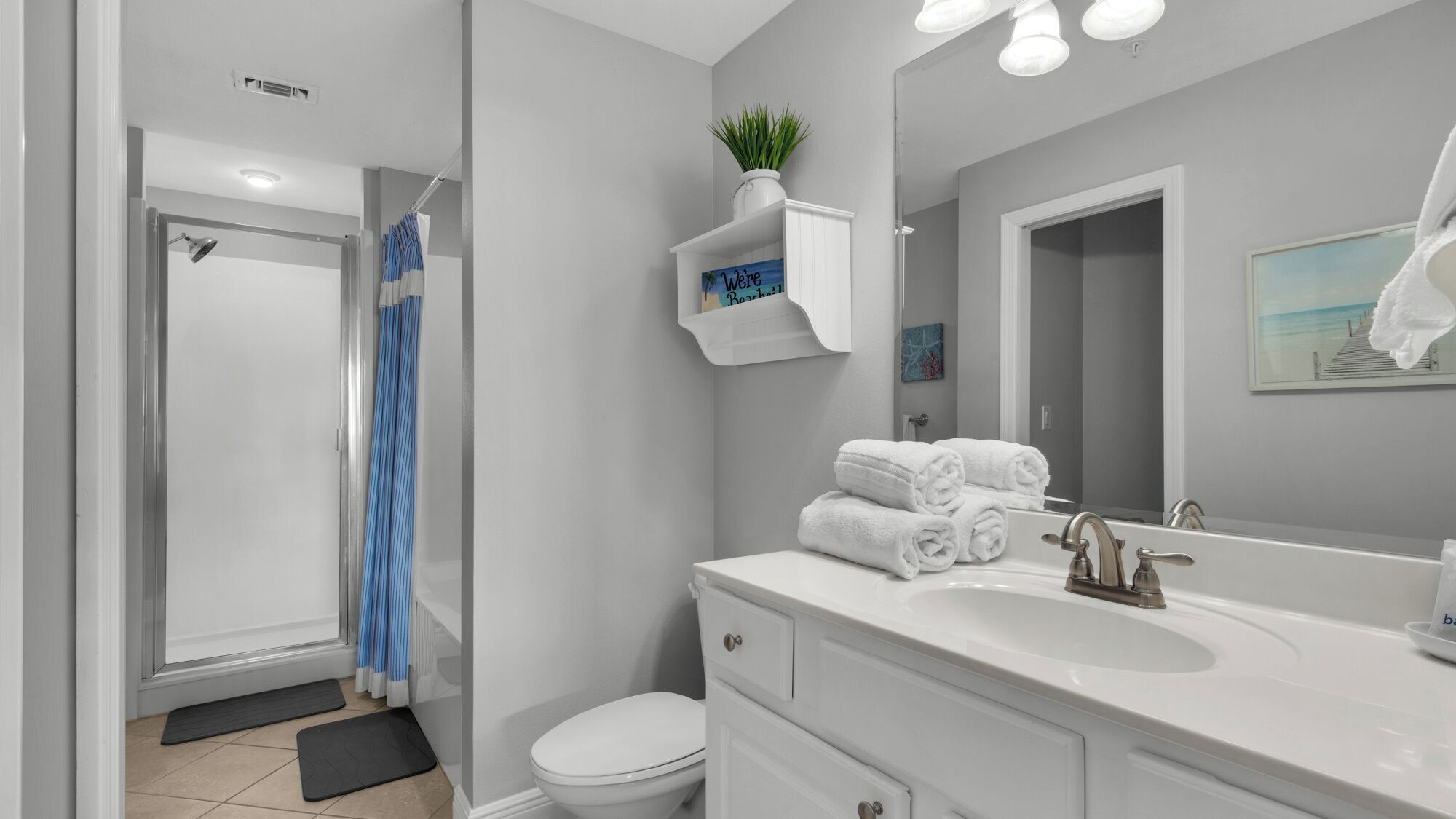 A modern bathroom with a shower, toilet, and sink.
