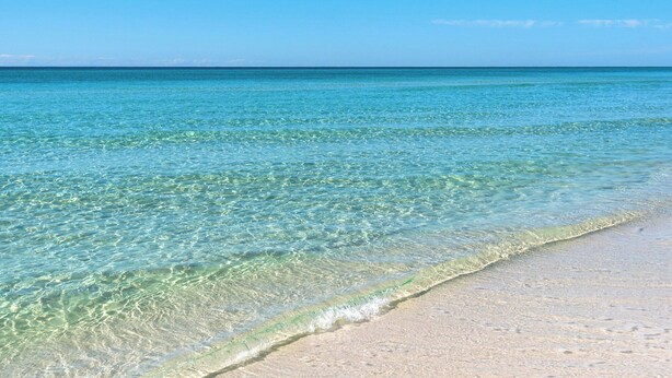 A beach with clear shallow waters and a sandy shore. - San Remo (Santa Rosa Beach)