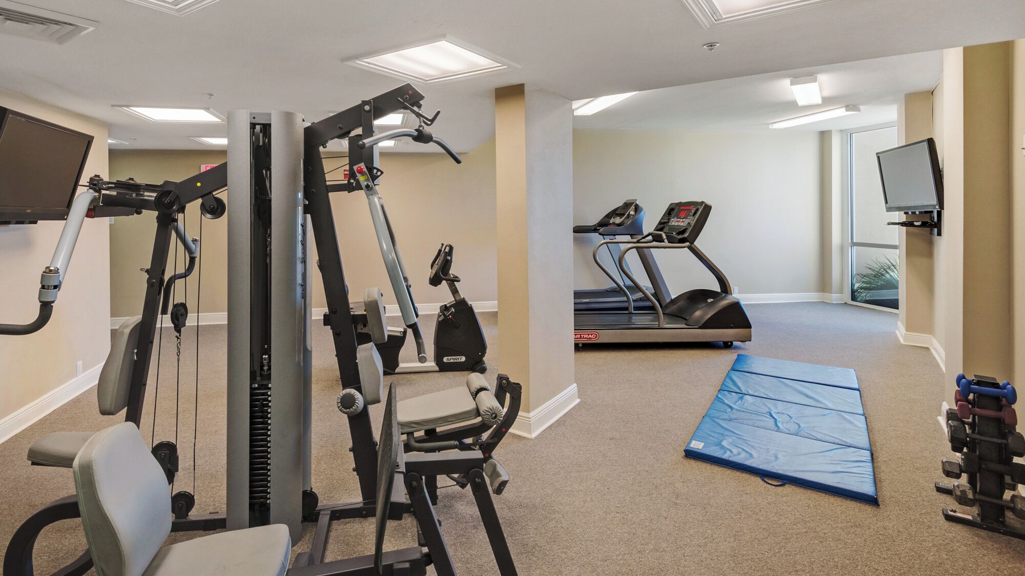 A gym with cardio machines, a treadmill, and a stationary bike.