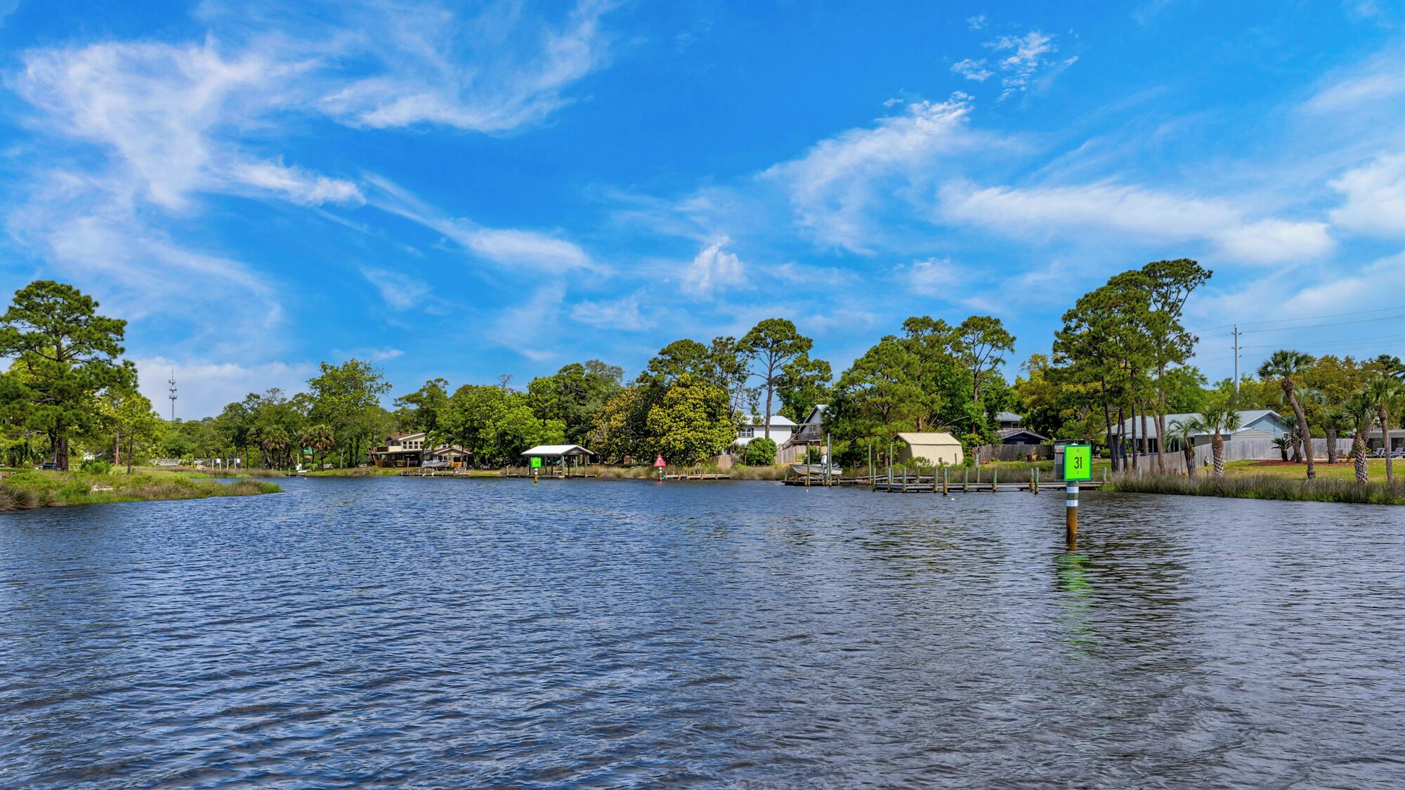 A waterfront property with a dock, a small building, and a sign with the number 31.