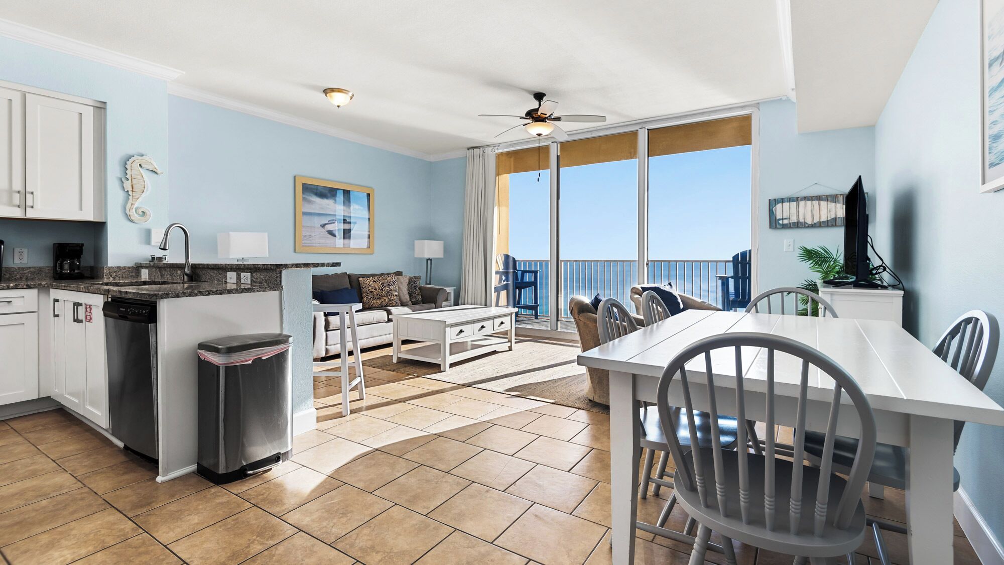 Une cuisine moderne avec un coin repas, un balcon offrant une vue agréable et un ventilateur de plafond.