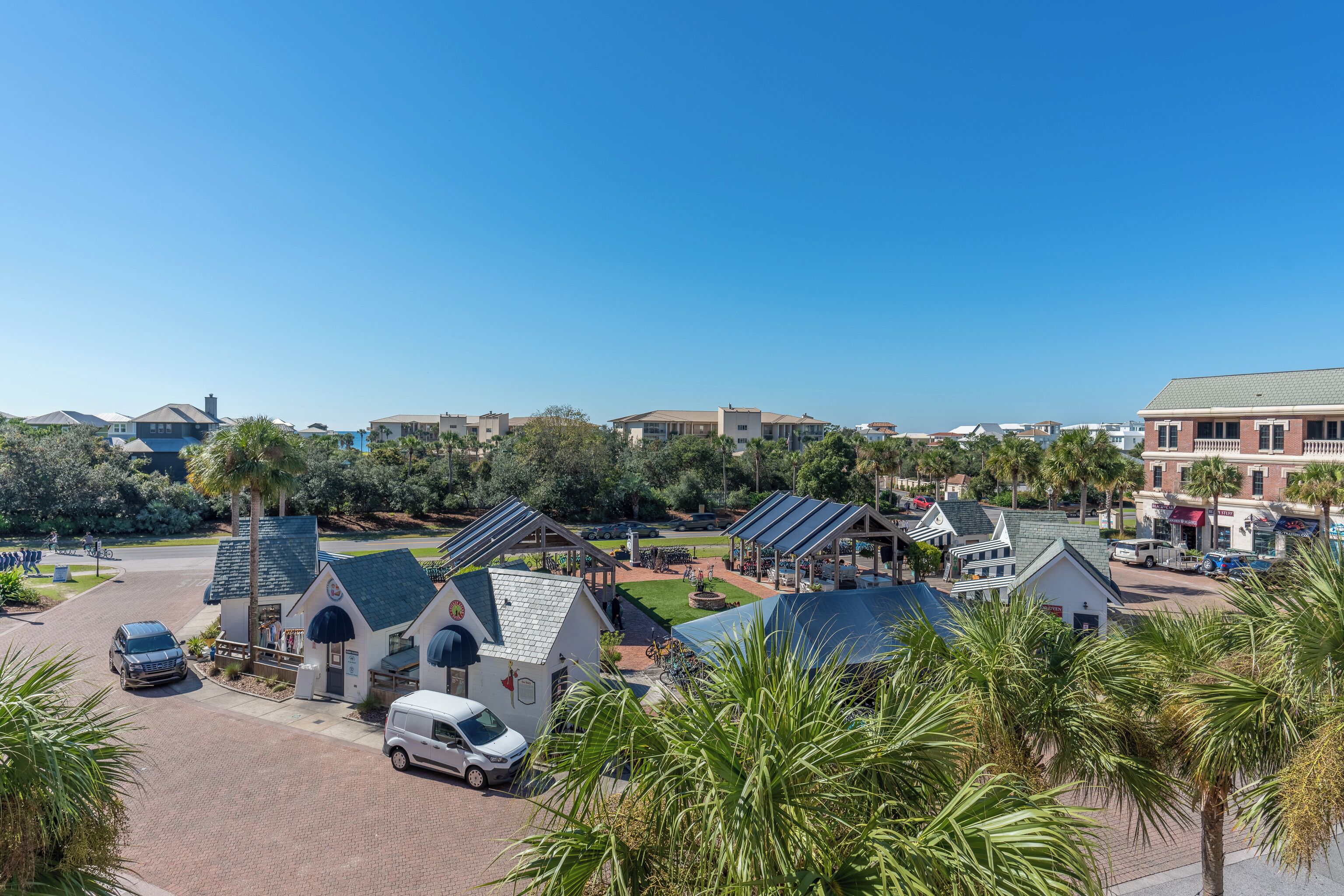 A residential area with houses, a parking lot, and solar panels on rooftops.