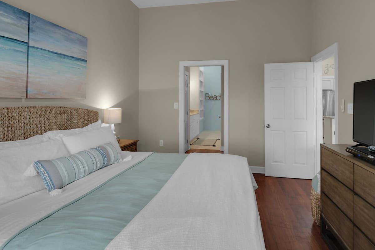 Relax in comfort with a large bed, flat-screen TV, and dresser in this inviting space.