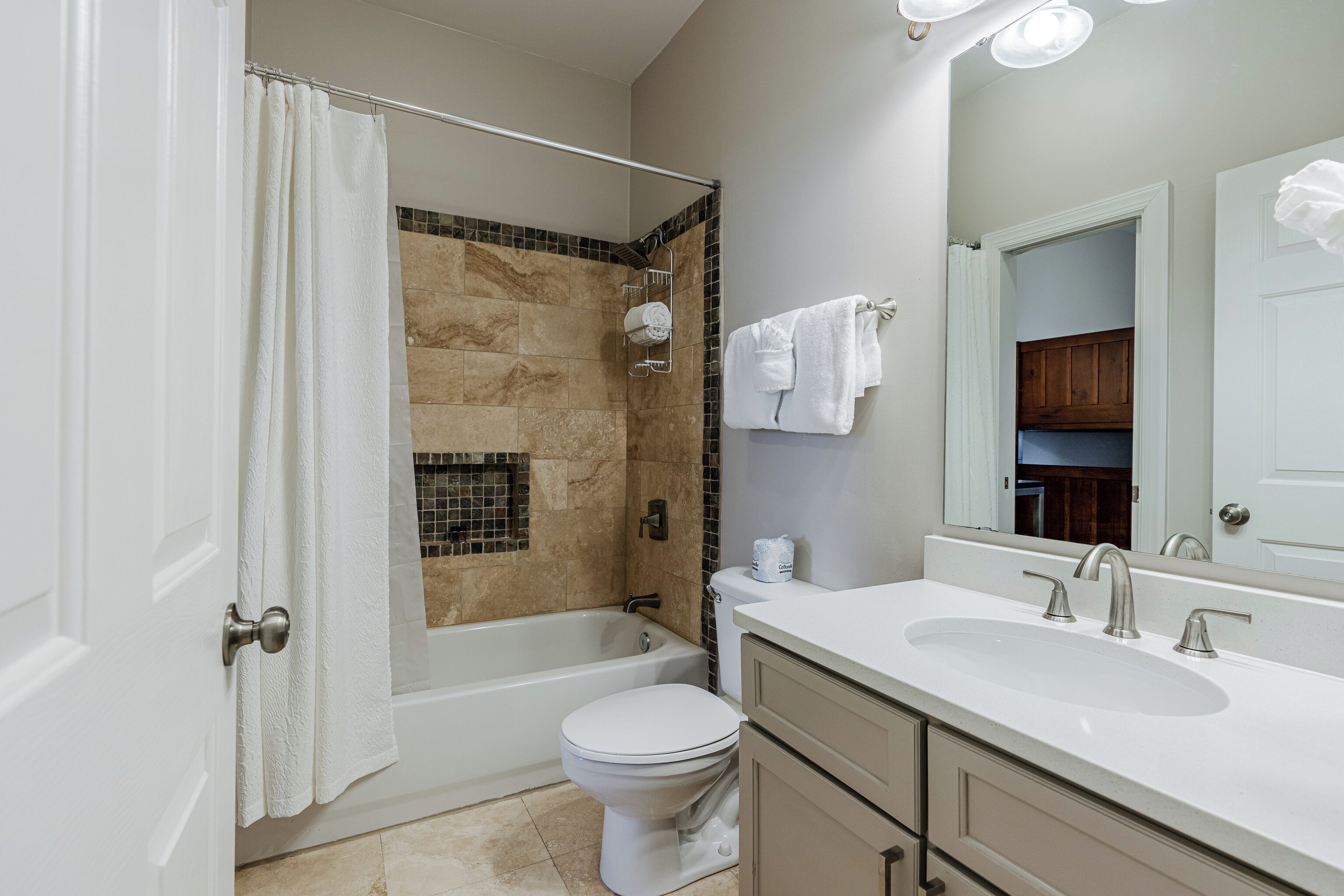 A bathroom with a bathtub, toilet, and sink.
