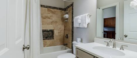 A bathroom with a bathtub, toilet, and sink.