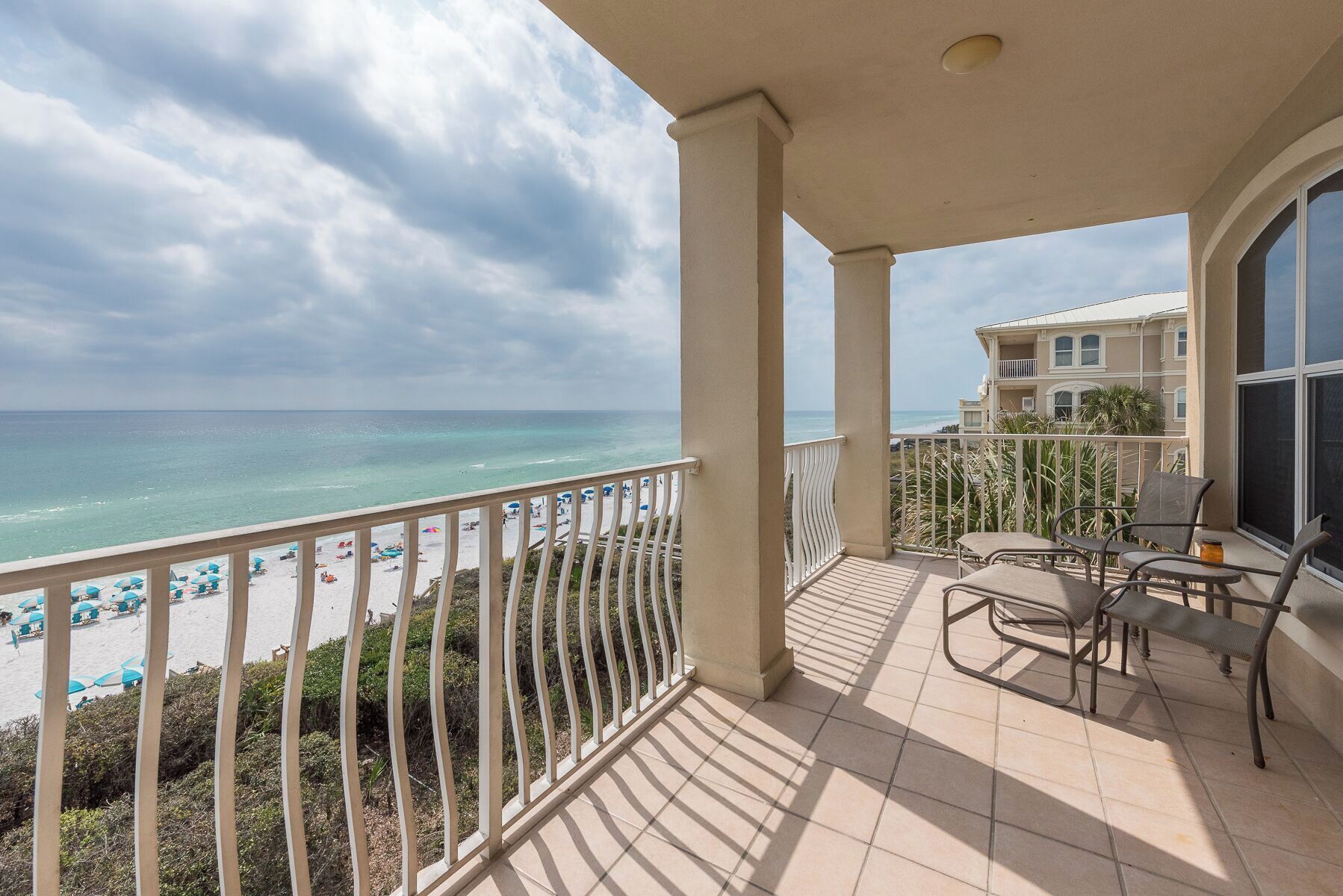 Ein Balkon mit Blick auf Strand und Meer.