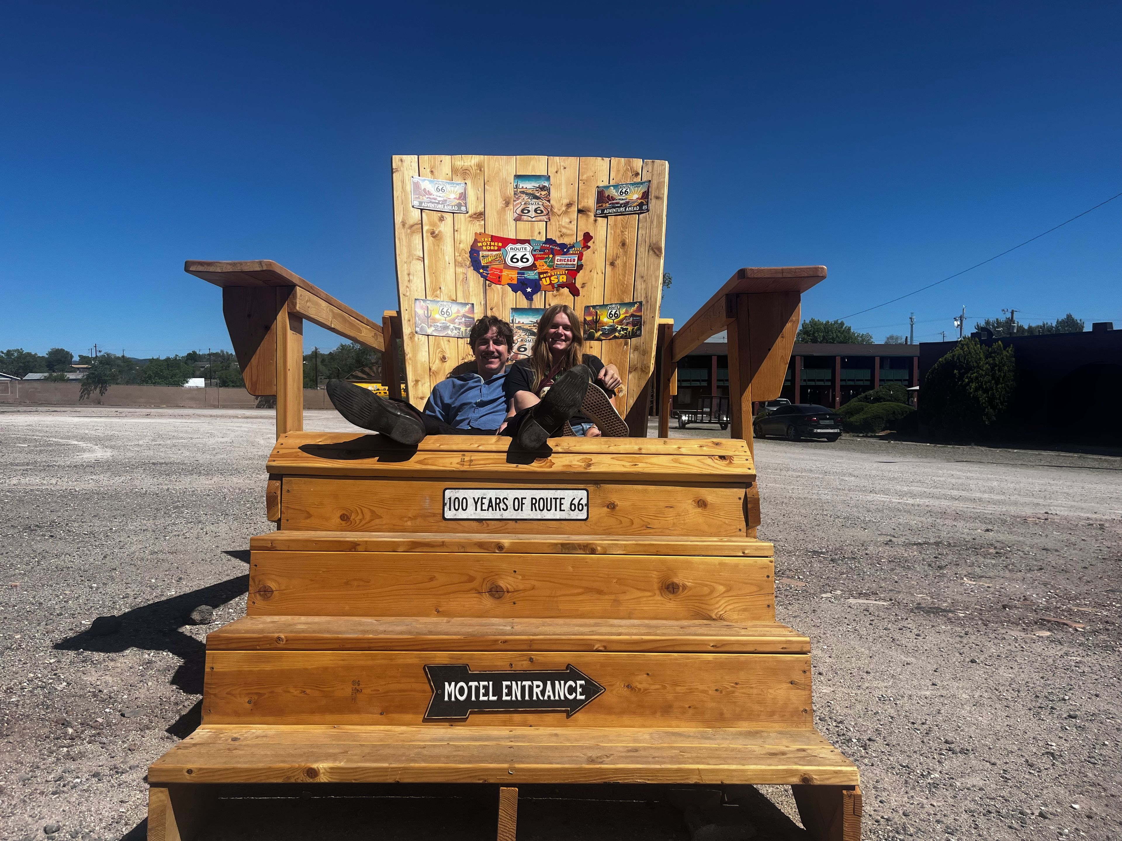 A wooden structure with a sign indicating '100 YEARS OF ROUTE 66' and 'MOTEL ENTRANCE' pointing to the right.