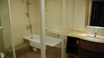 A bathroom with a glass-enclosed shower, a bathtub, and a vanity with a sink.