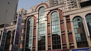 A hotel with a large arched window design, multiple floors, and a sign indicating it is a business hotel. - Hong Cheng Sing Business Hotel (Tainan)