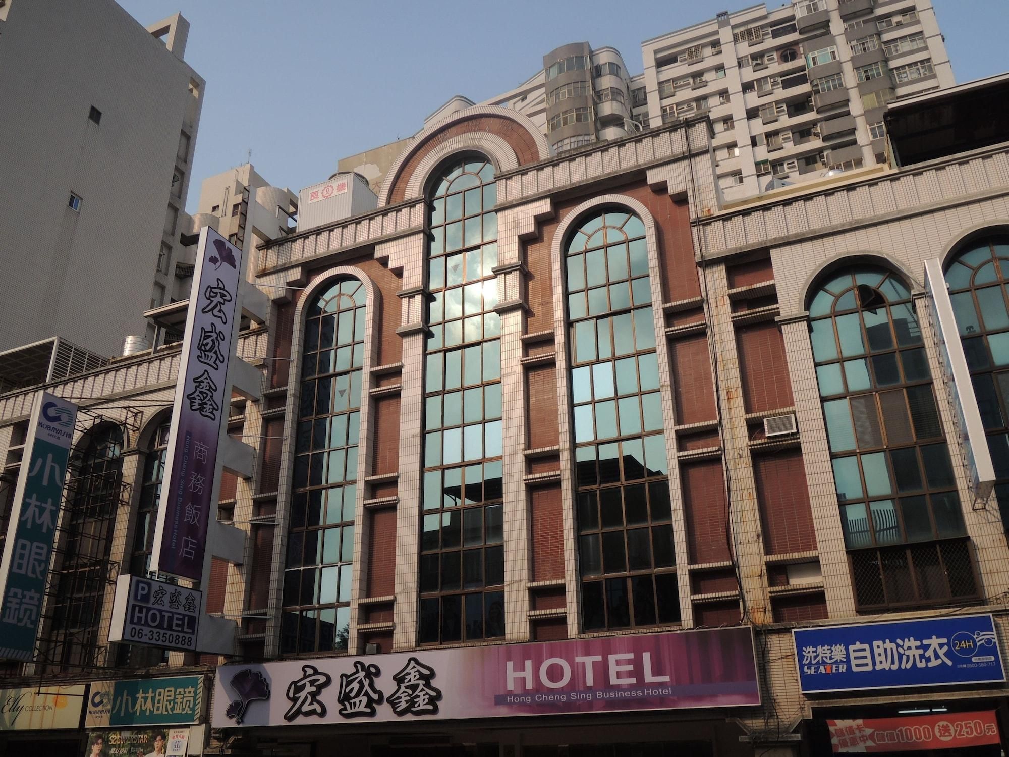 A hotel with a large arched window design, multiple floors, and a sign indicating it is a business hotel.