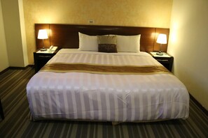 A hotel room with a large bed, two bedside tables, and lamps. - Hong Cheng Sing Business Hotel (Tainan)