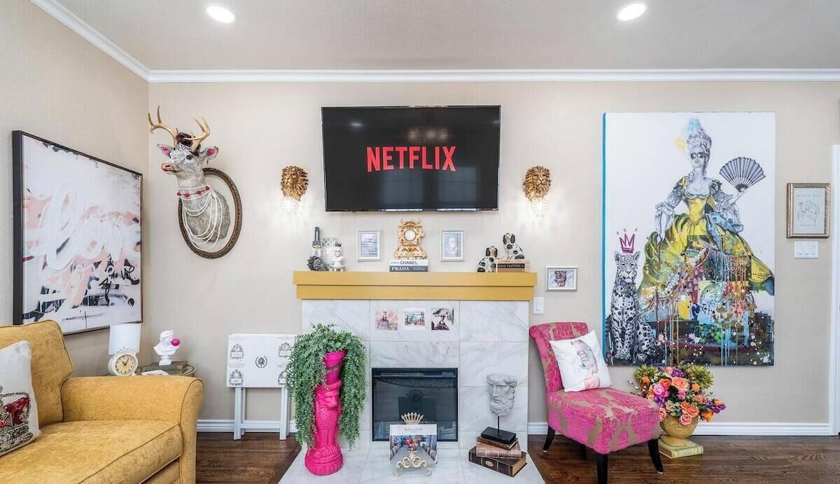 A living room with a fireplace, a mounted television, and various decorative items.