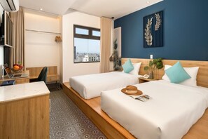 Une chambre d’hôtel avec deux lits, un bureau, un ordinateur portable et une vue sur la ville.