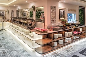 Un buffet proposant une variété de plats et d’ustensiles, un sol à motifs et un aménagement intérieur moderne.