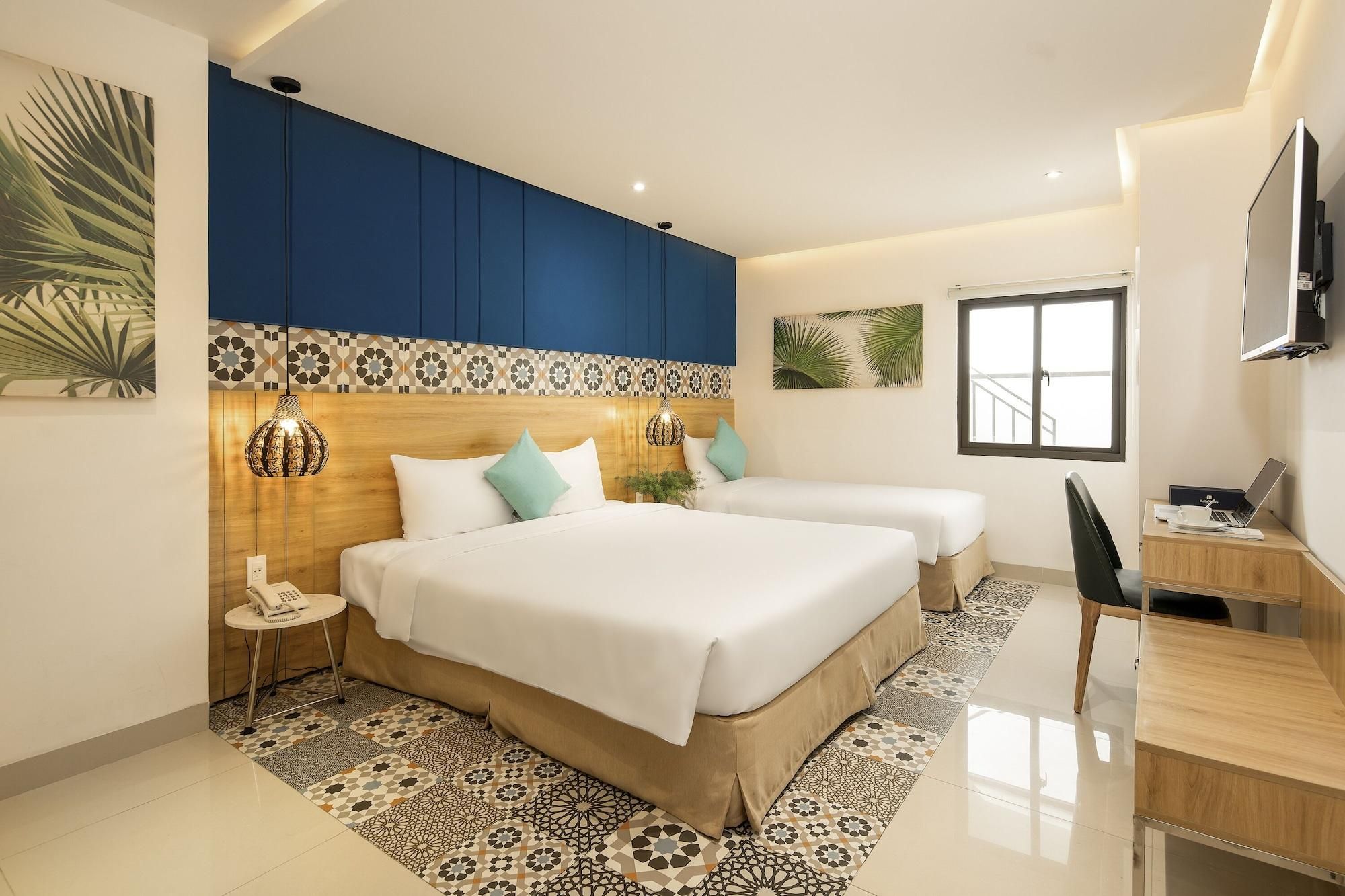 A modern hotel room with a large bed, a desk, and a TV.