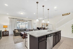 A modern kitchen with a central island, dark cabinetry, and pendant lighting. - 2027 MD - Windsor Westside Tranquil Haven (Kissimmee)