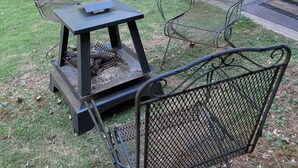 A metal grill with two mesh chairs and a small table in a grassy outdoor area. - Delightful Atlanta family- sized apt. Sleeps 6 & pet friendly. (Atlanta)