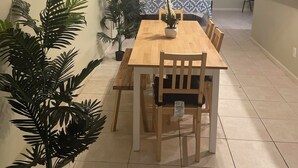 A dining area with a wooden table and chairs, surrounded by potted plants. - Delightful Atlanta family- sized apt. Sleeps 6 & pet friendly. (Atlanta)