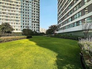 A well-maintained grassy courtyard surrounded by modern buildings with large windows.