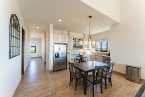 Una cocina moderna con una isla central, electrodomésticos de acero inoxidable y un comedor.