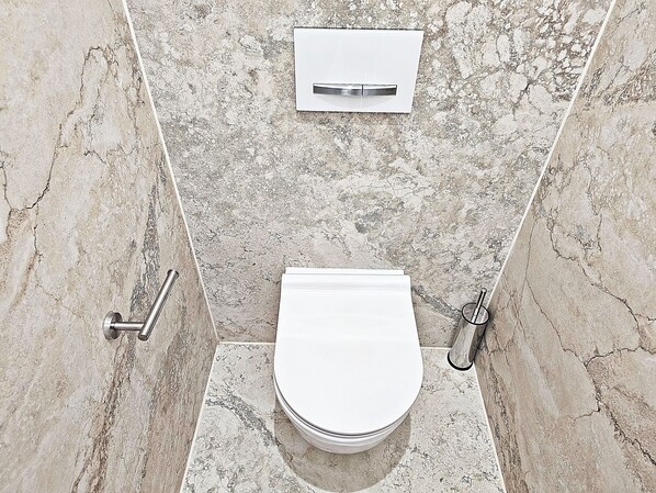 A modern bathroom with a white toilet, a wall-mounted bidet, and a shower control panel. - Panorama Prestige Penthouse- BEST LOCATION IN TOWN (Split)