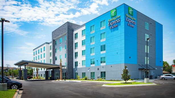 A Holiday Inn Express & Suites hotel with a modern design, featuring a blue and white facade, multiple floors, and a covered entrance area. - Holiday Inn Express & Suites Pensacola Airport North – I-10 by IHG (Pensacola)