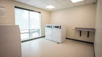 A laundry room with a large window, a washer, and a dryer.