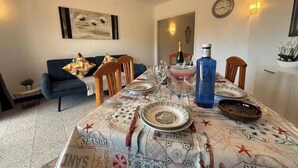 A dining area with a table set for four, featuring a map-themed tablecloth, a bottle of water, and various dishes.