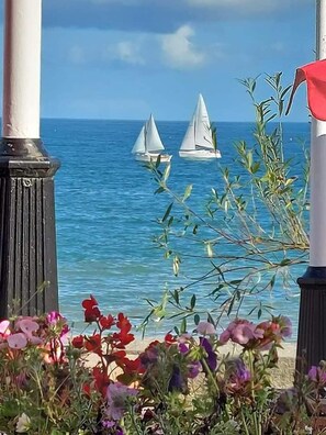 A view of the sea with two sailboats, a wooden railing, and some flowers in the foreground. - 2bed Chalet Sleeps 5 - Dogs Free, Parking, Seaview (Bridlington)