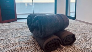 Una habitación con una cama, un ventanal grande y un armario oscuro.