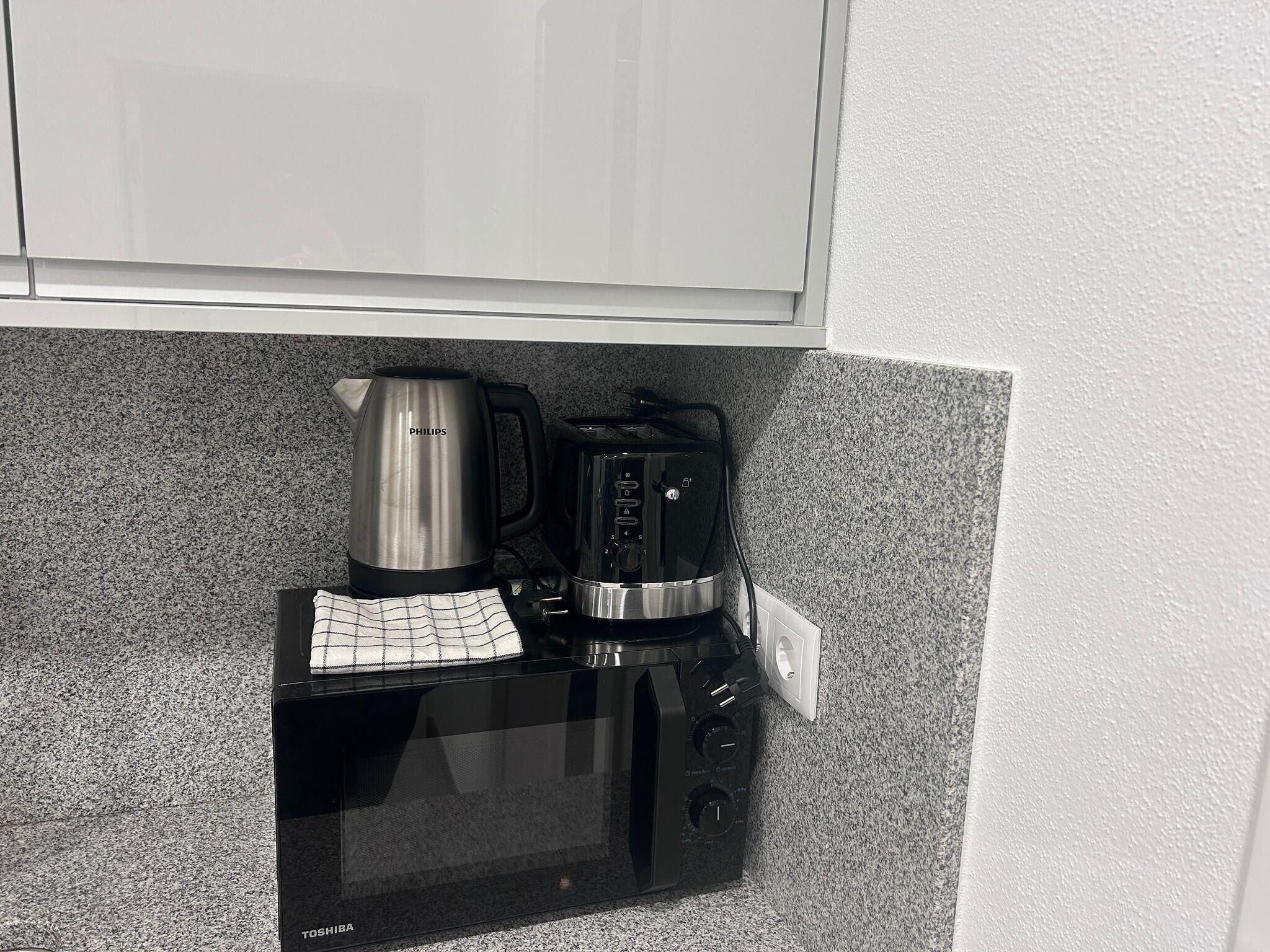 Eine Küche mit Mikrowelle, Kaffeemaschine und Toaster.