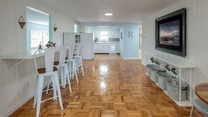 A spacious kitchen with white cabinets and a dining area with white chairs.