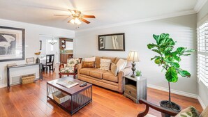 A living room with a brown sofa, a coffee table, a floor lamp, and a large potted plant. - Peaceful Poway Vacation Rental Near Shops & Dining (Poway)