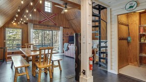 Un intérieur en bois comprenant un coin repas, un escalier et un panneau indiquant une station-service.