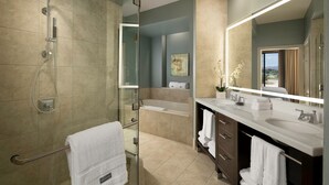 A modern bathroom with a glass-enclosed shower, a bathtub, and a vanity with a large mirror.