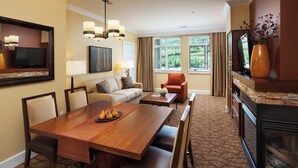 A hotel room with a wooden dining table, a sofa, a chair, a television, and a fireplace. - The Westin Riverfront Mountain Villas, Beaver Creek Mountain Studio
 (Avon)