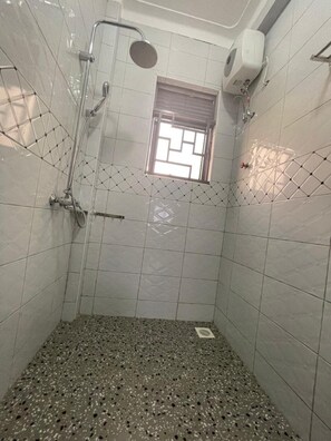 Chuveiro, toalhas de banho, sabonete, papel higiênico