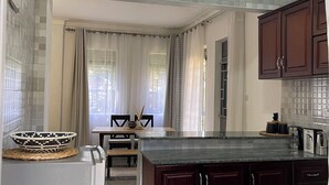 Una cocina moderna con encimera de mármol, armarios de madera oscura y salpicadero de azulejos.