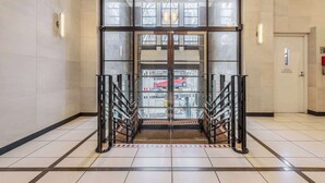 A hotel entrance with a glass door, a staircase, and a view of the street outside. - Vintage glamour with indoor pool in heritage CBD (Melbourne)