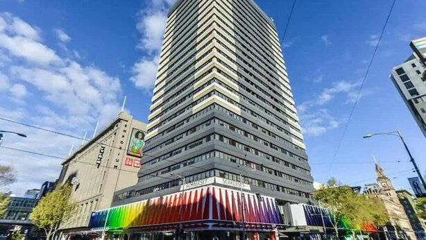 Un edificio alto y moderno con un patrón en zigzag característico en su fachada.