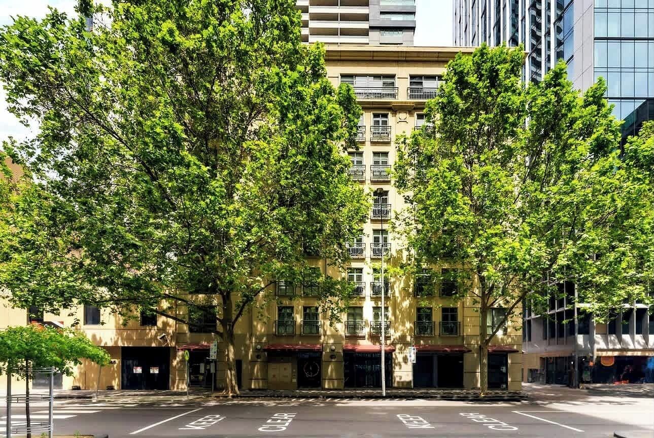 A multi-story building with a central courtyard, surrounded by trees.