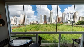 Ein Balkon mit Blick auf eine Stadtlandschaft, einem runden Tisch und zwei Stühlen.