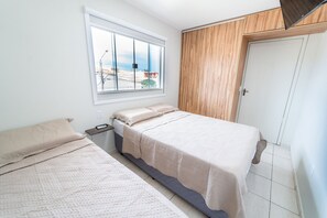 Een slaapkamer met een bed, een raam en een deur.